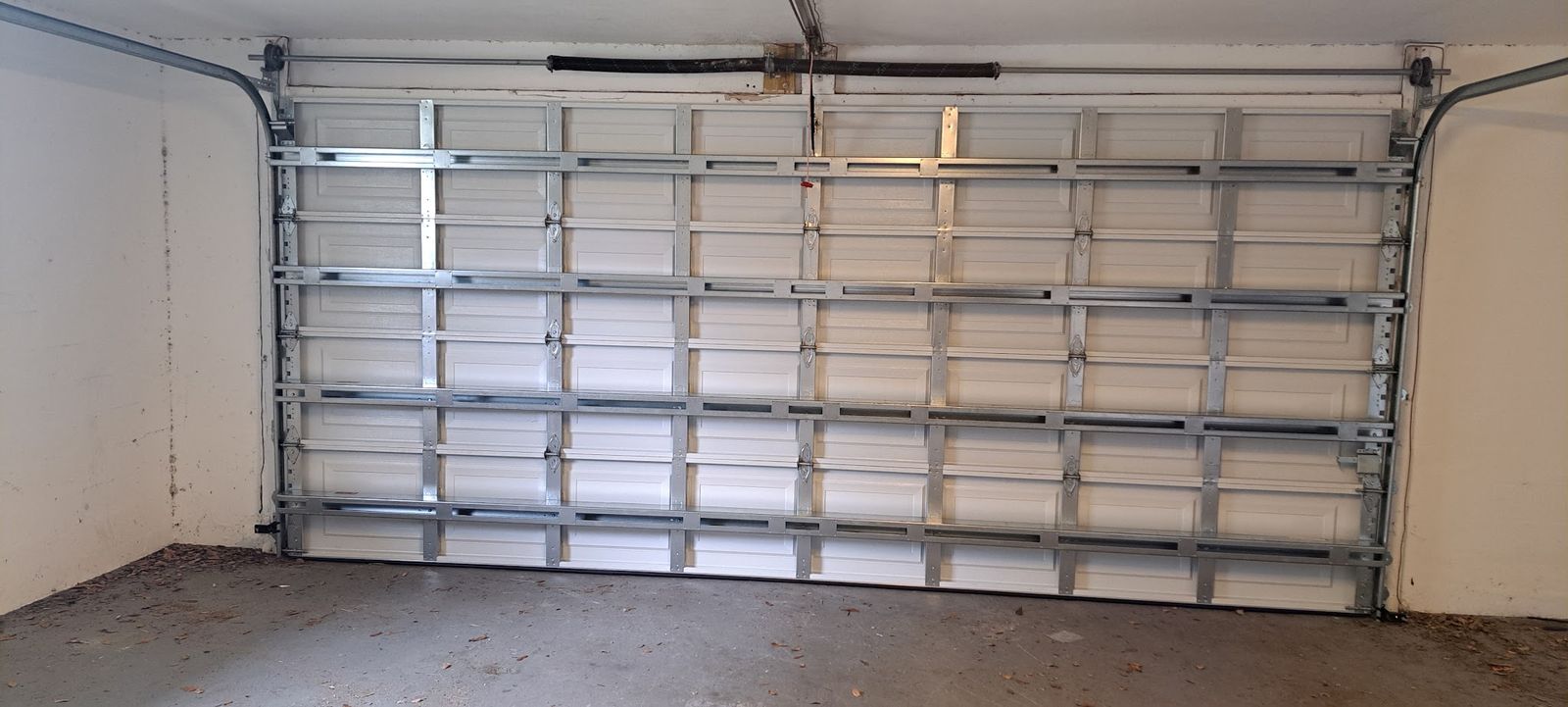 Interior of a double-car garage door with full-width metal struts and side tracks