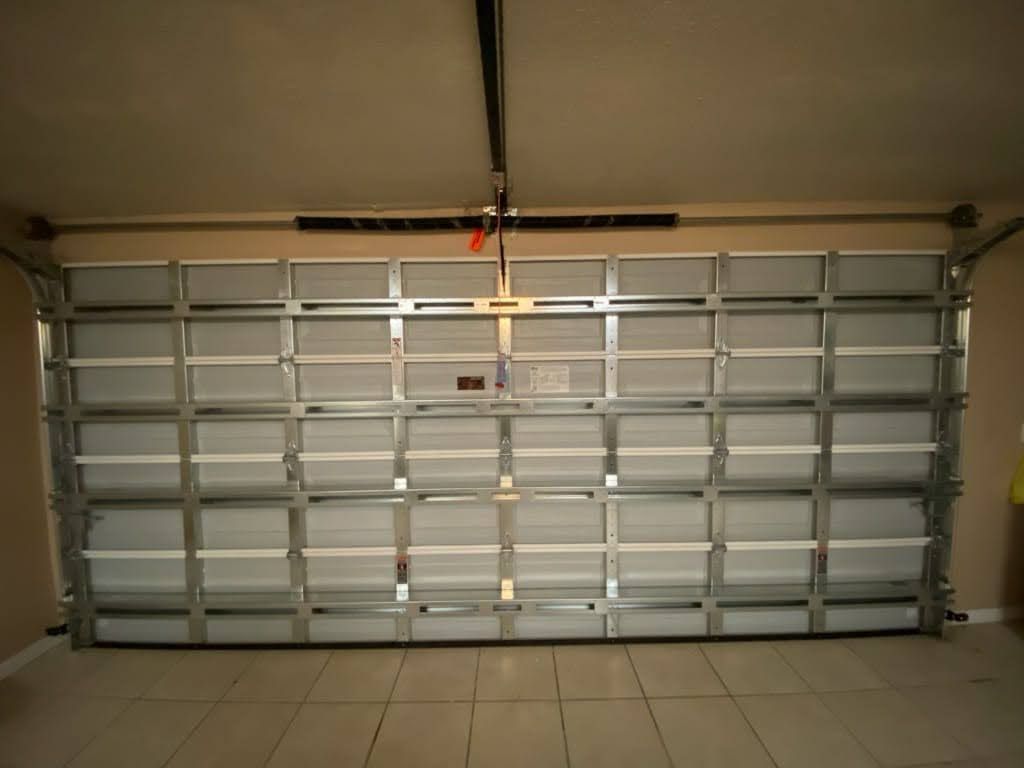 Interior garage door with multiple horizontal struts, tracks, and a tiled floor