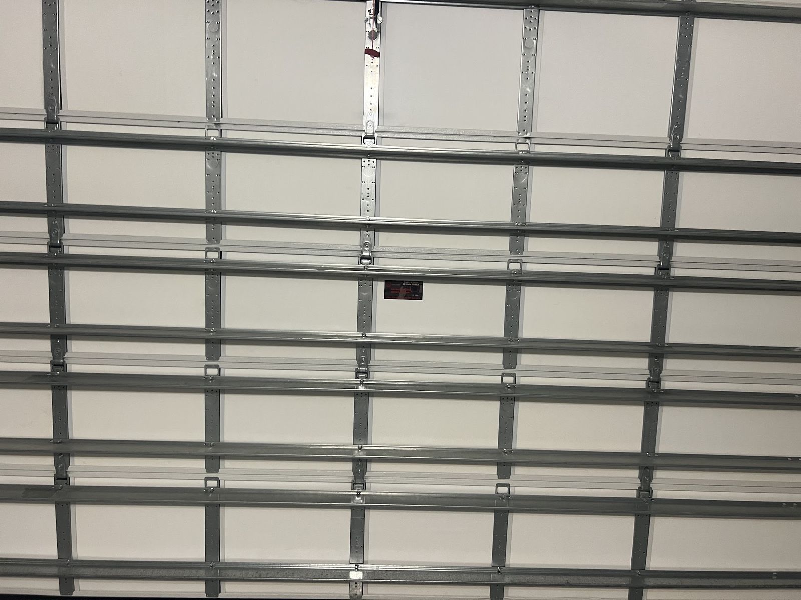 Interior of a white sectional garage door with horizontal struts and hinges